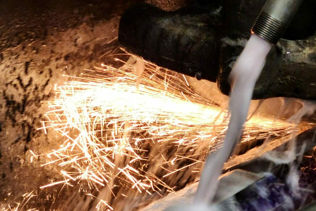 Sparks flying from tool steel being sharpened on Hanchett grinding machine