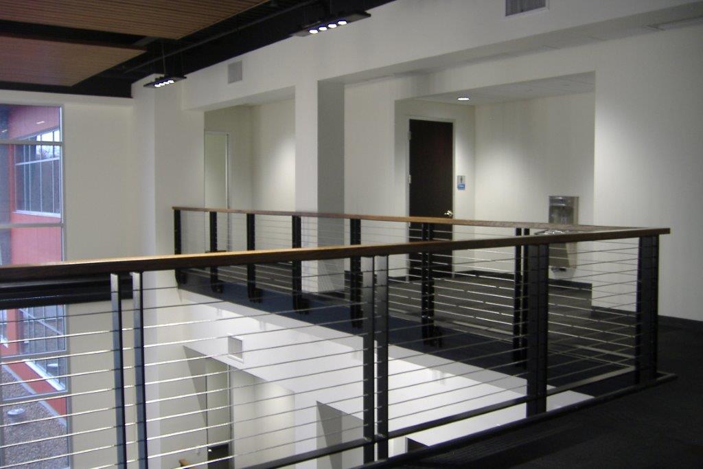 Interior balcony railing with wire cabling barrier in office building